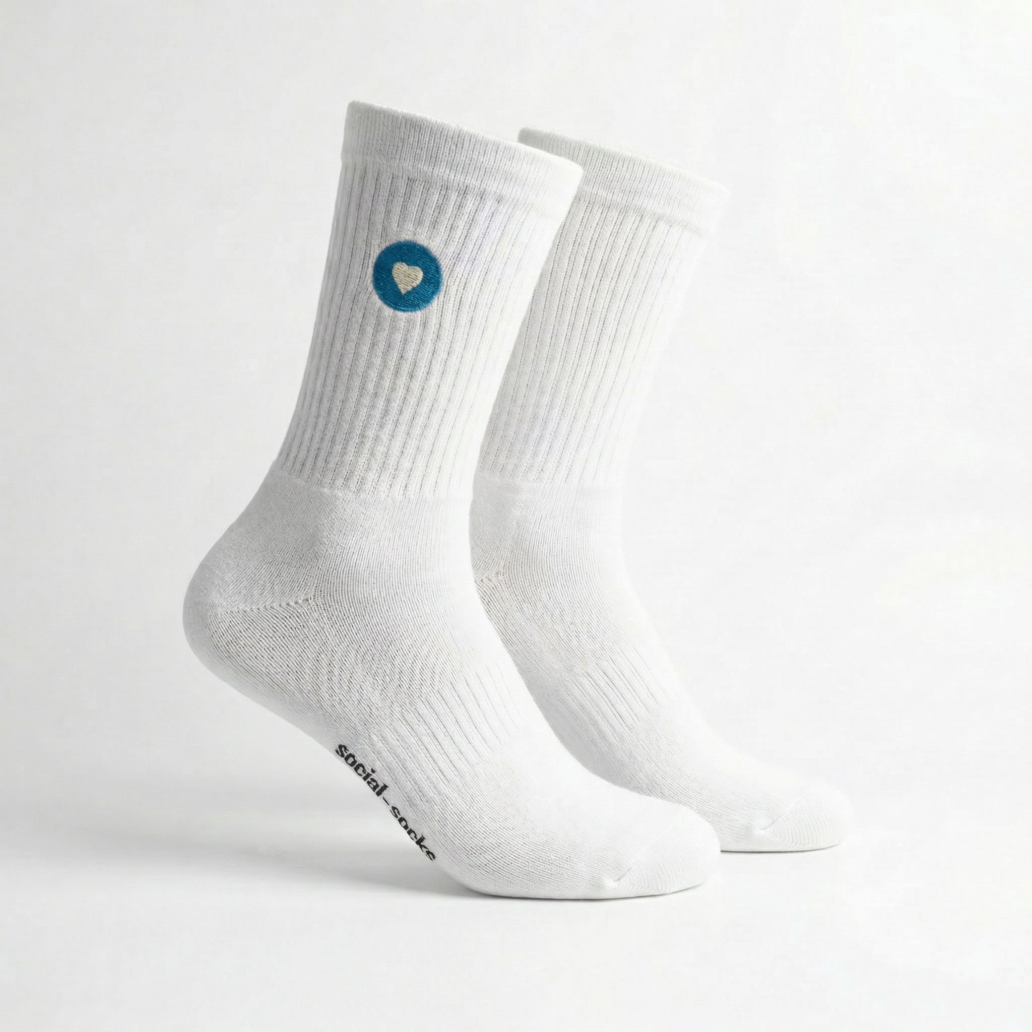 Weisse Premium Socken aus Bio-Baumwolle mit blauem Herzlogo vor weissem Hintergrund.