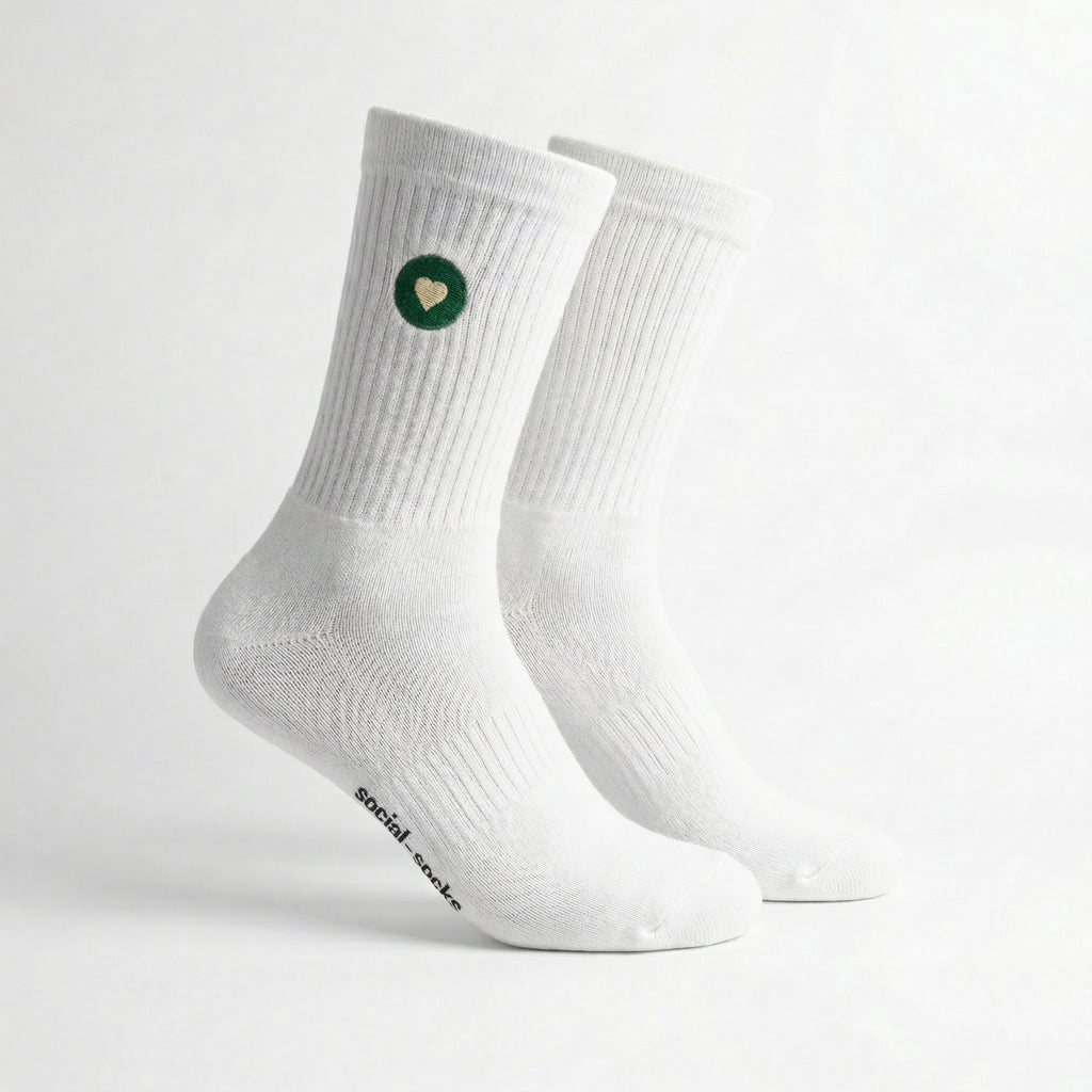 Weisse Premium Socken aus Bio-Baumwolle mit grünem Herzlogo vor weissem Hintergrund.